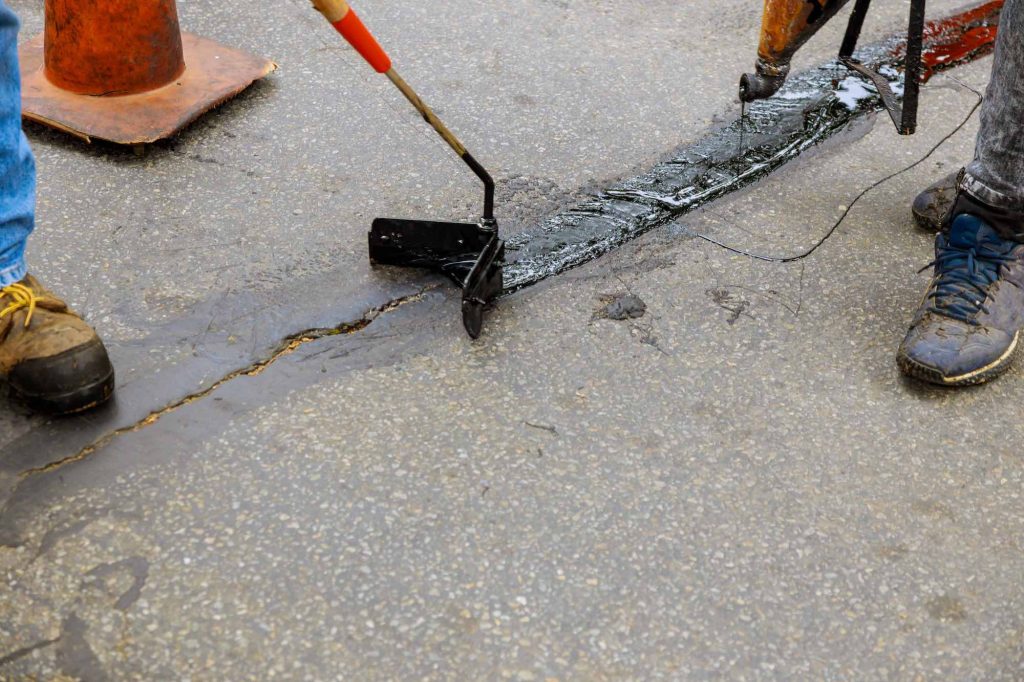 Hot crack filler being applied to a pavement joint