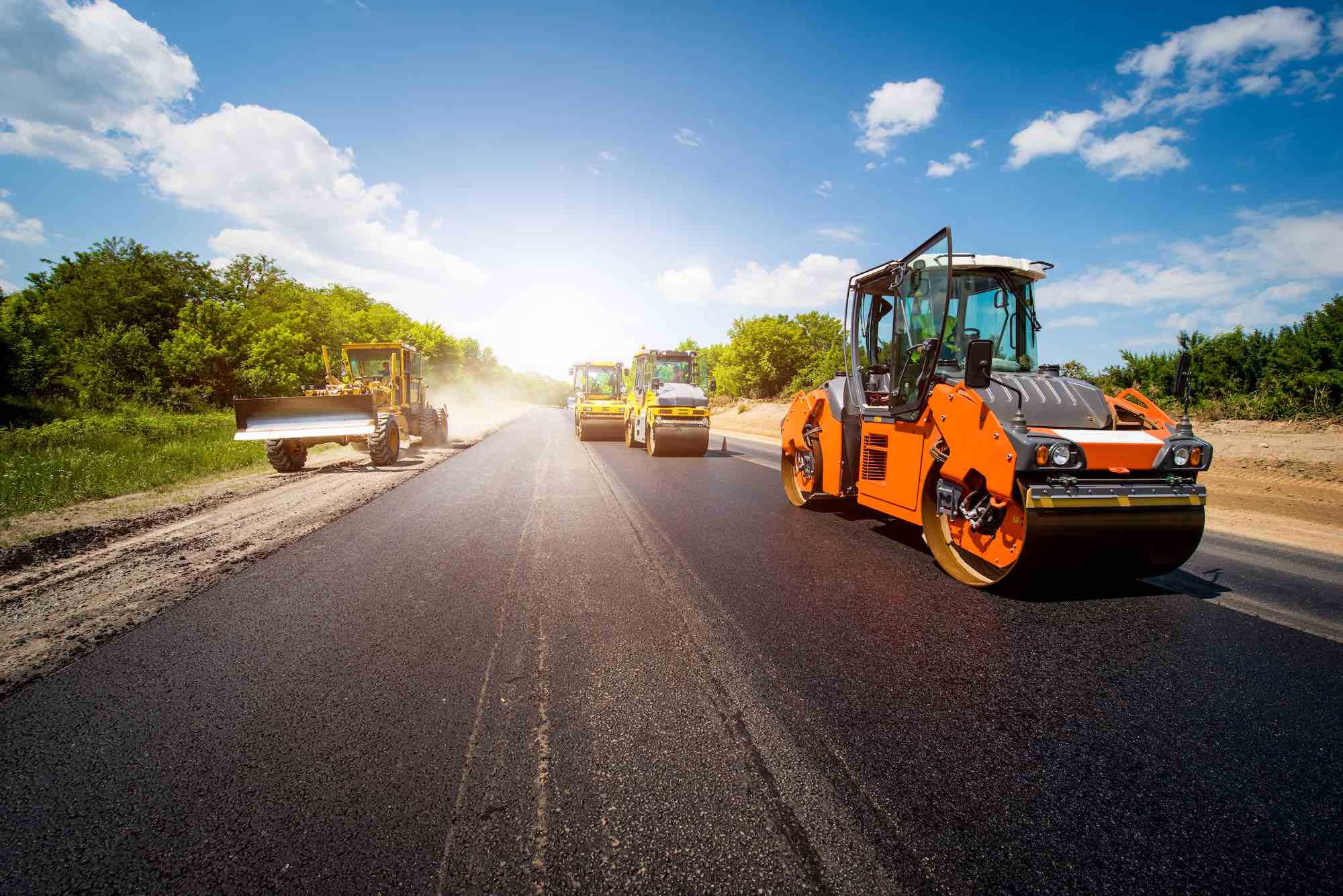 Road paving equipment working on fresh asphalt