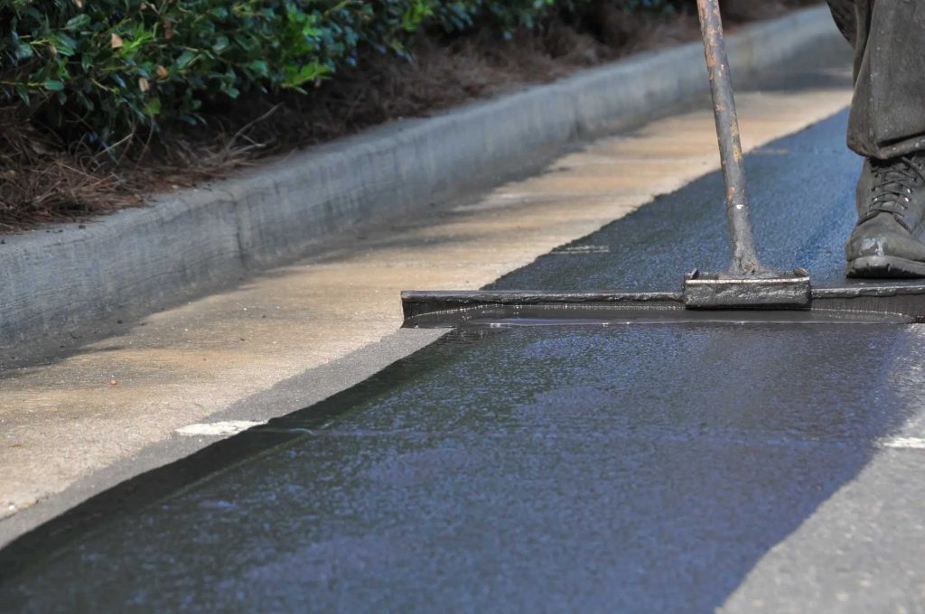 Sealcoat being squeegeed along a curb line