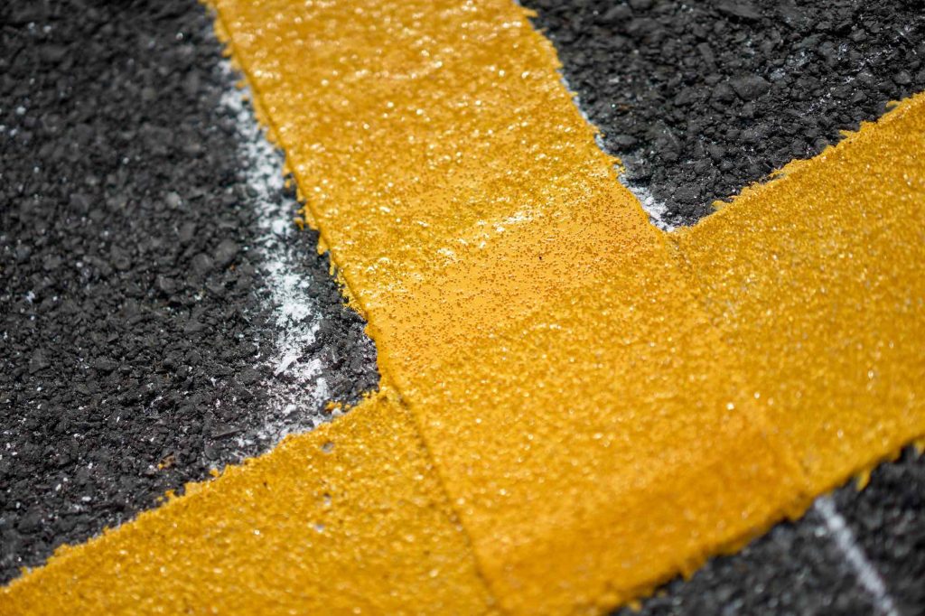 Fresh yellow line striping on new asphalt