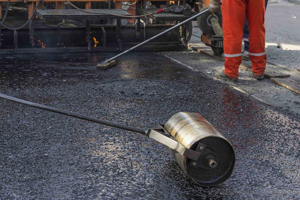 Hand roller compacting fresh asphalt